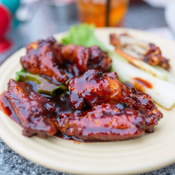 Rookies Sports Bar & Grill's BBQ chicken wings with celery sticks and lettuce on a plate.
